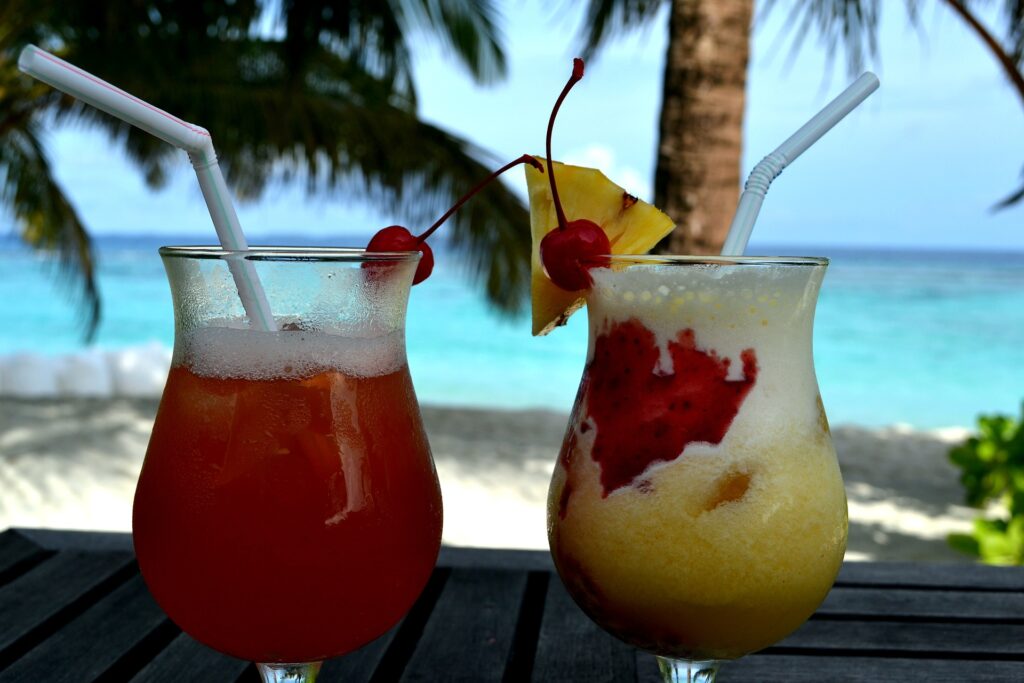 aperitivo a ukulhas immagine rappresentante due cocktail appoggiati su un tavolino in riva al mare alle maldive